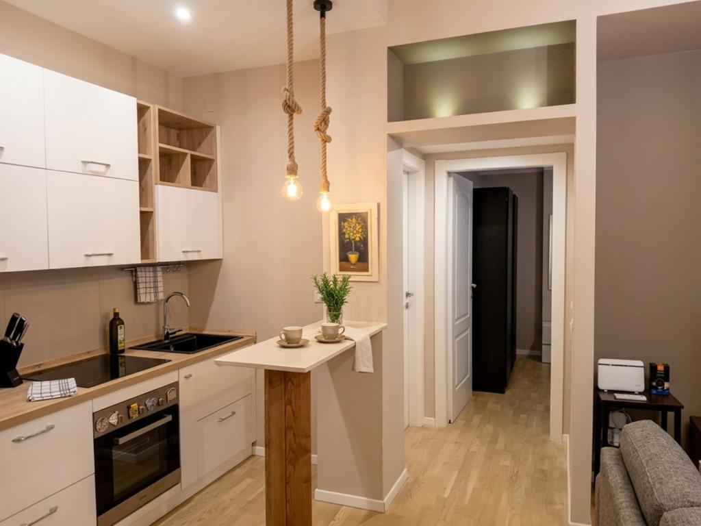 a kitchen with white cabinets and a table in it at Aura Deluxe Apartments in Syracuse