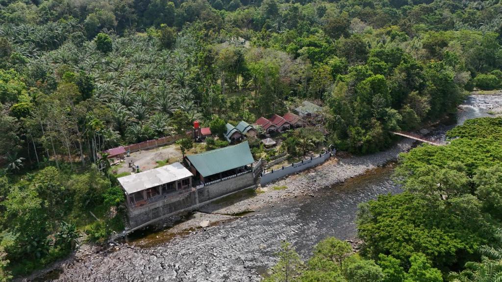an aerial view of a house next to a river at Asim Paris Guesthouse & jungle trekking in Bukit Lawang