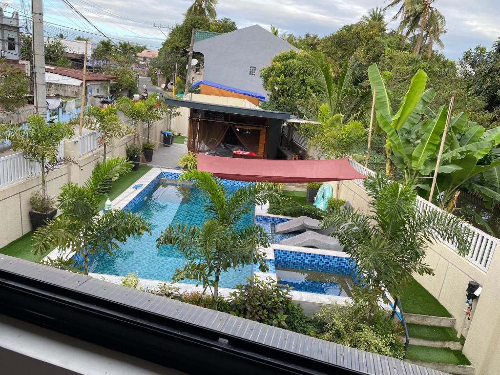 an overhead view of a swimming pool with palm trees at Casa Sandrine resort in Malolos
