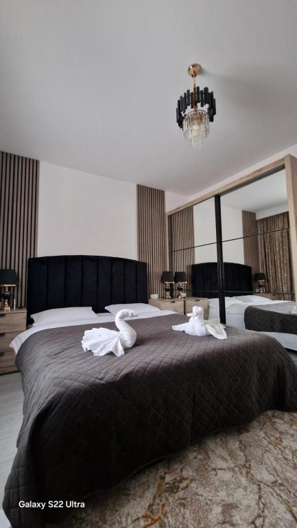 a bedroom with a large bed with towels on it at Apartament EVA in Suceava