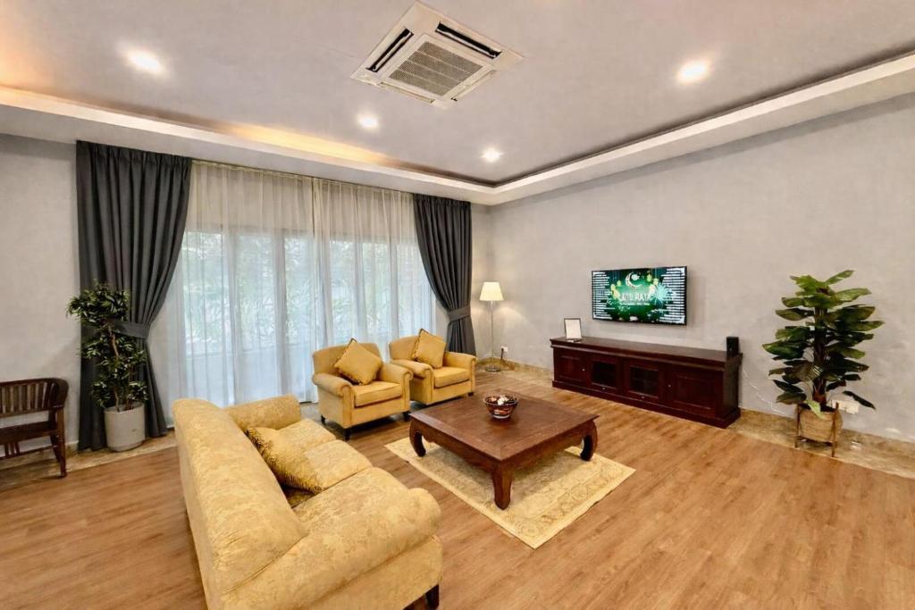 a living room with a couch and a tv at Villa Alam Klang managed by Bella Vista Hotels & Resorts in Klang