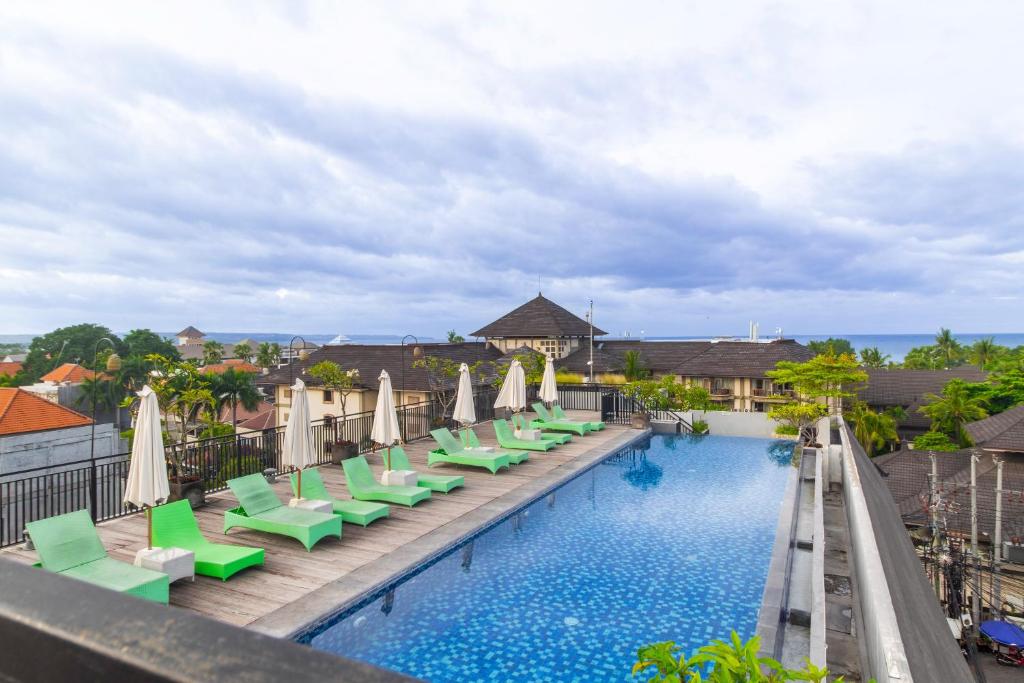 a view of a pool with chairs and umbrellas at Palette Legian Beach in Legian