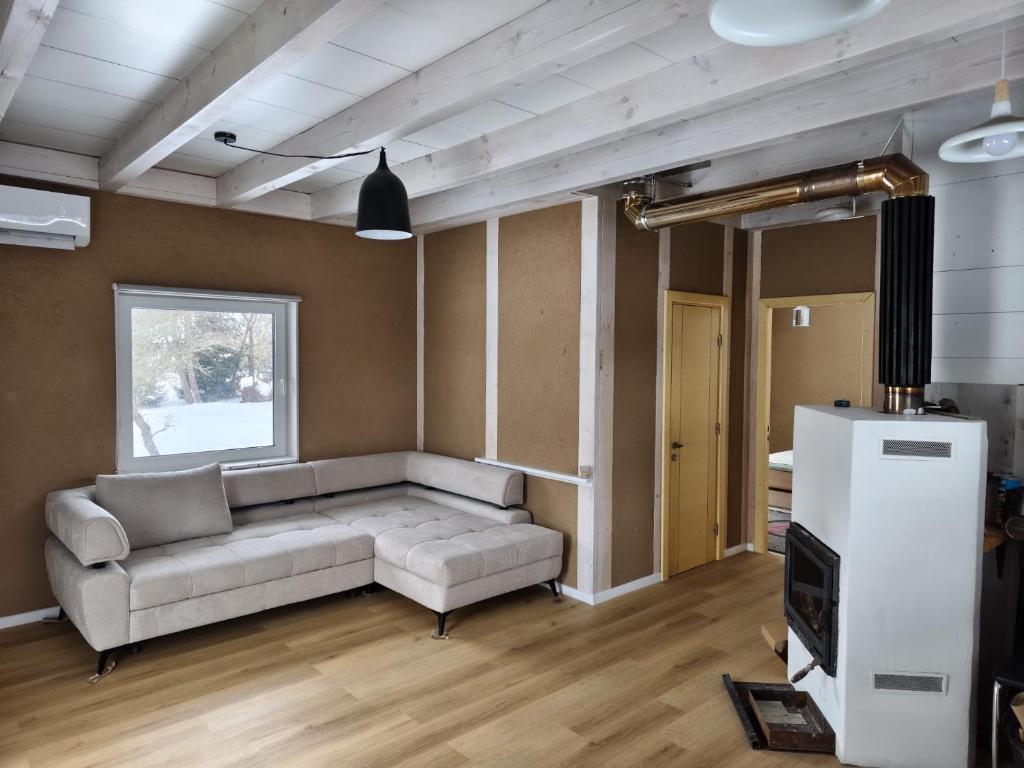 a living room with a couch and a tv at Brīvdienu māja in Jelgava