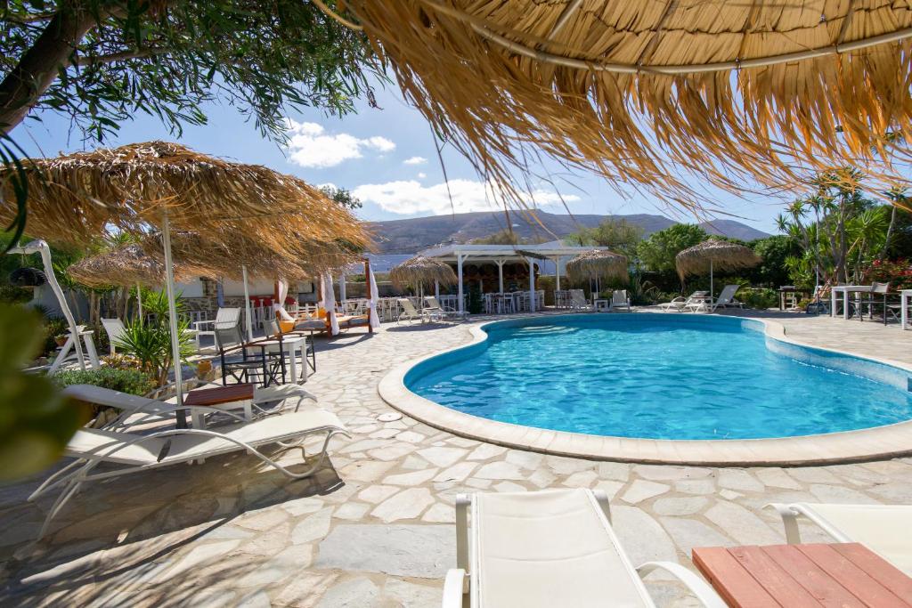 a pool at a resort with chairs and umbrellas at Boutique Hotel Onira in Parikia