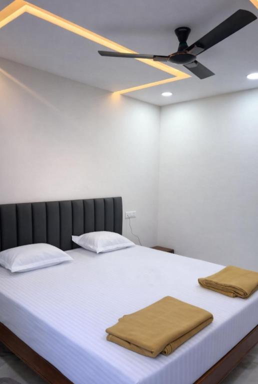 a large bed with two towels on top of it at Pallaki Residency in Hubli