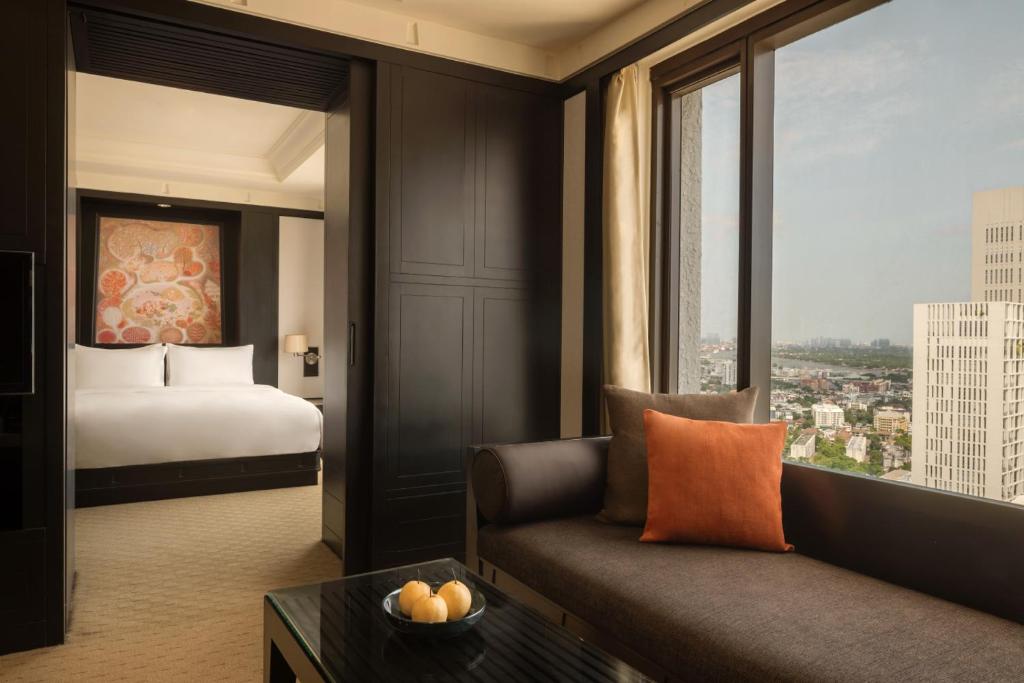 A sitting area beside a separate bed space, with a high-rise city view.