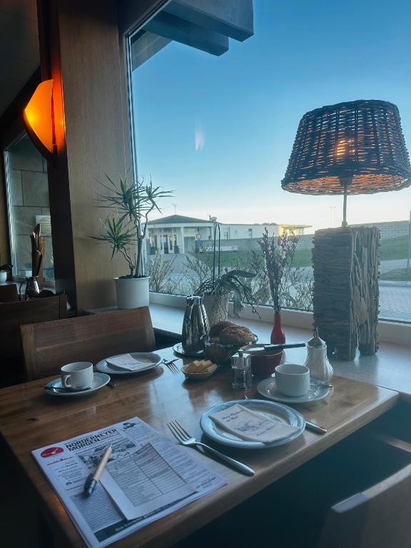 a wooden table with plates and utensils on it at Hotel Haus Margarete am Meer in Norderney