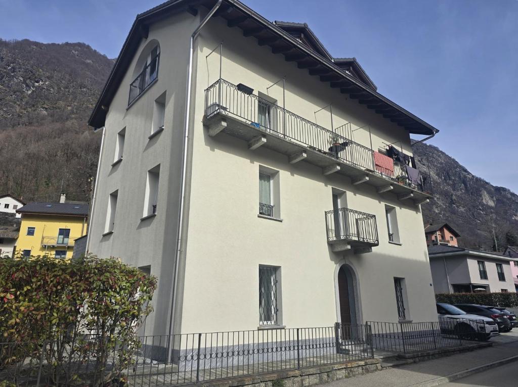 a large white building with two balconies on it at Casa Chiara in Cavergno