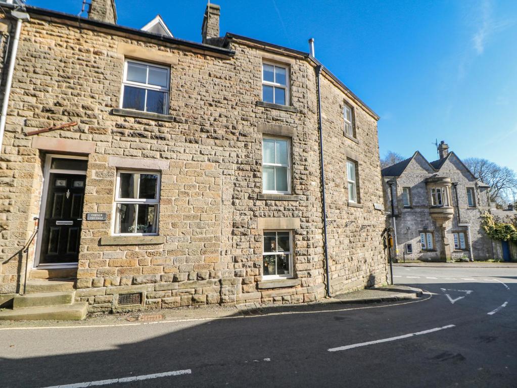 an old brick building on the side of a street at Corner Cottage in Buxton