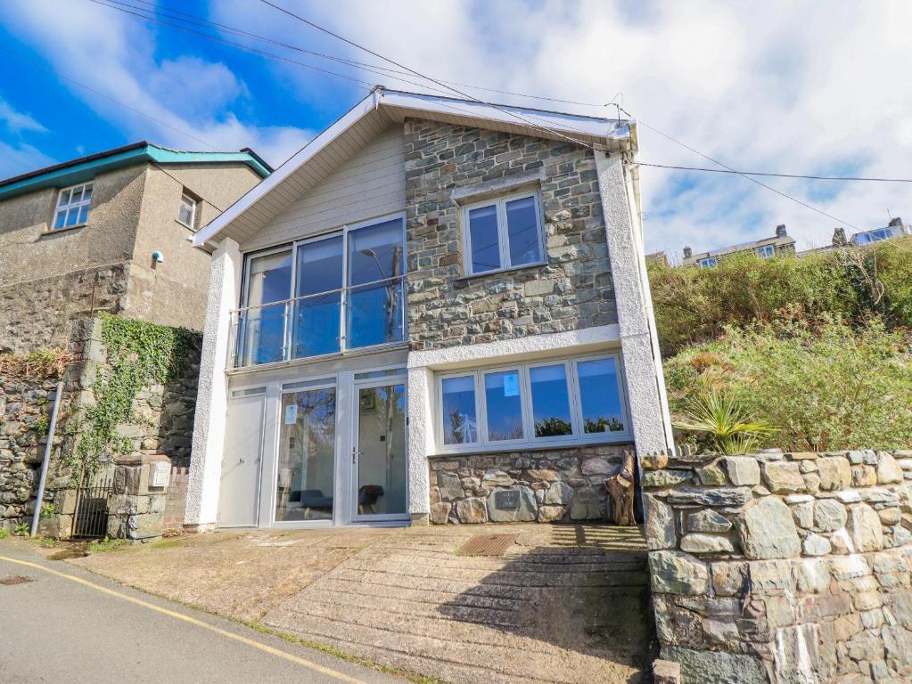 a stone house with a stone wall at Hafod Y Bryn in Harlech