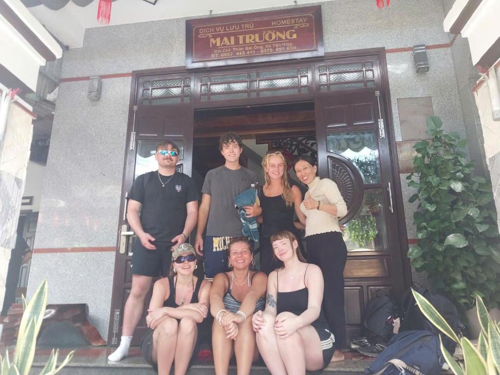 a group of people posing in front of a building at Homestay Mai Trường Cù Lao Chàm in Tân Hiệp