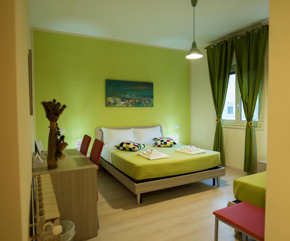 - une chambre avec un lit et un mur vert dans l'établissement B&B Giunone, à Agrigente