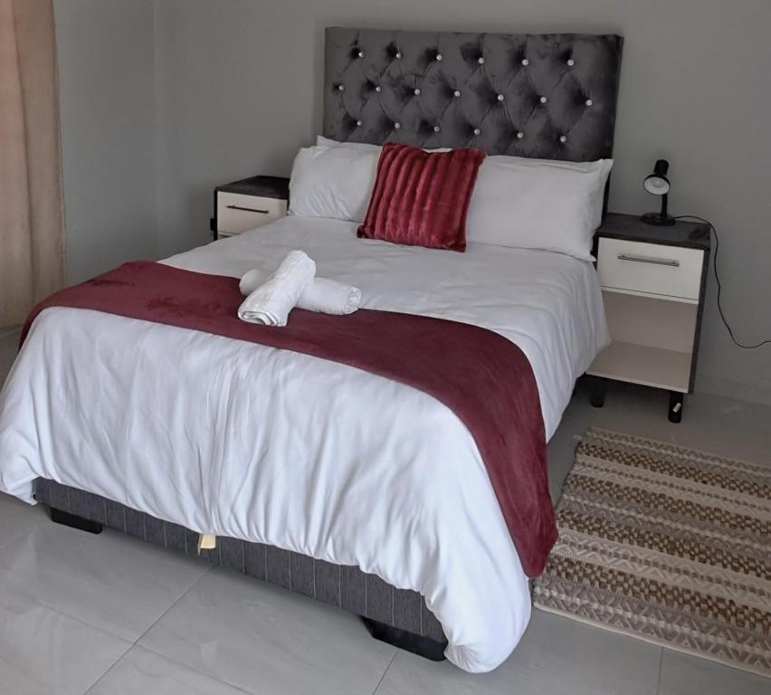 a bedroom with a large bed with two stuffed animals on it at Florino GuestHouse in Rundu