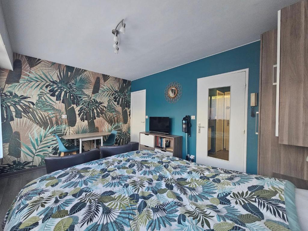 a bedroom with a large bed with blue walls at Studio 2 étoiles proche thermes avec parking in Aix-les-Bains