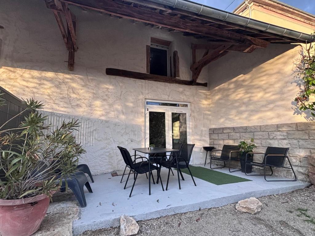 a patio with a table and chairs in a house at Appartement t4 évasion avec terrasse Week-end détente in Briord