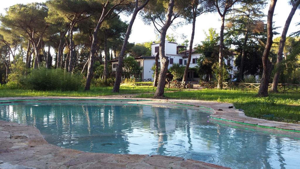 蓬泰加雷里亞的住宿－Agriturismo Tenuta La Muratella，水池,有房子的背景