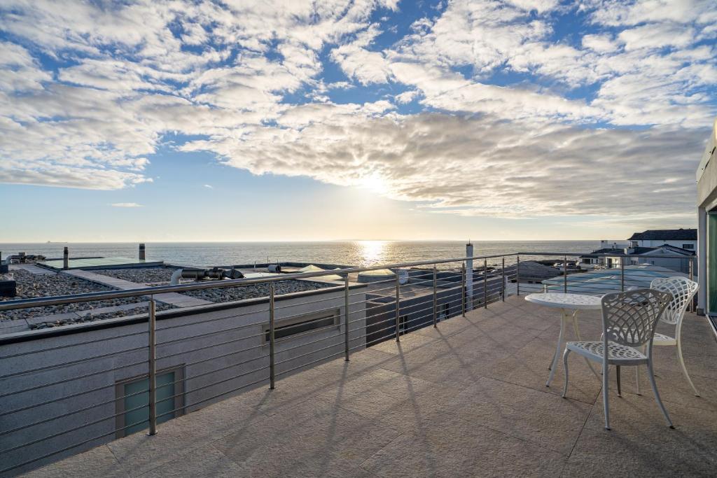 a balcony with a table and chairs overlooking the ocean at The Lighthouse in Cape Town