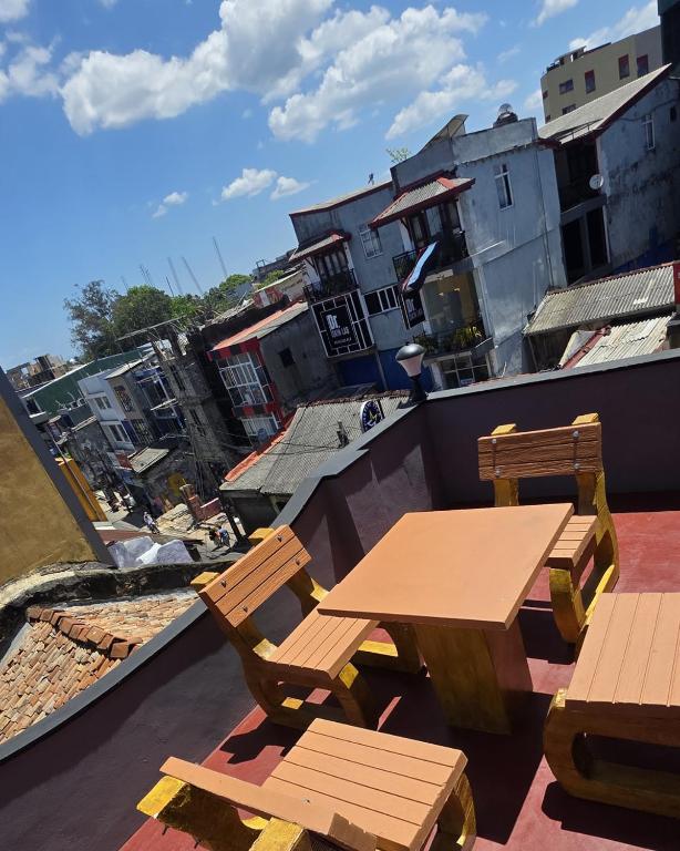 a wooden table and chairs on a roof with buildings at Aliya Stay in Galle