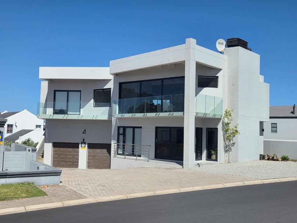 a white building with glass windows on a street at SeeSkattie in St. Helena Bay