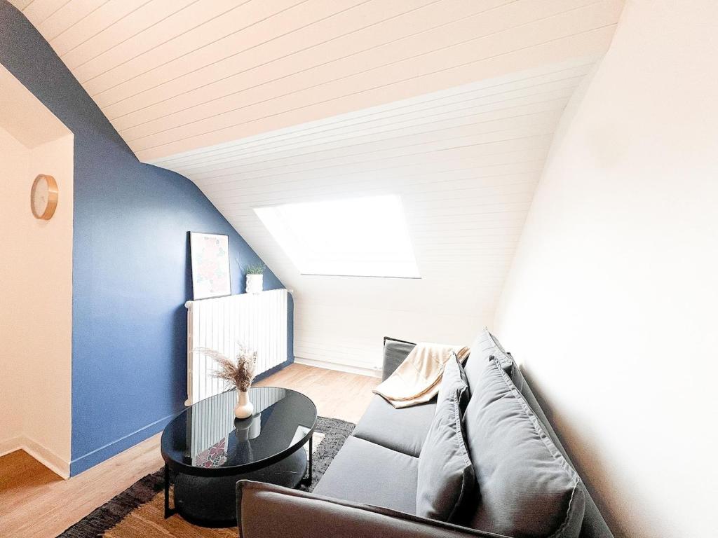 a living room with a couch and a table at L'Orchidée Marine, T2, 100m plage et du commando in Saint-Nazaire