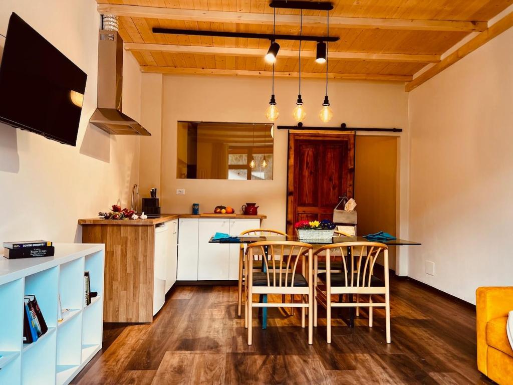 a kitchen and dining room with a table and chairs at Primiero Suite 3 downtown, garden in Transacqua