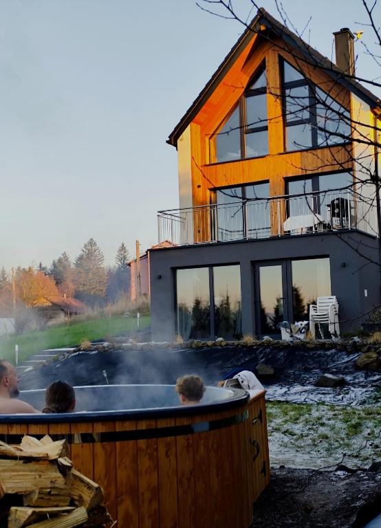 a hot tub in front of a house at Wśród Gór in Istebna