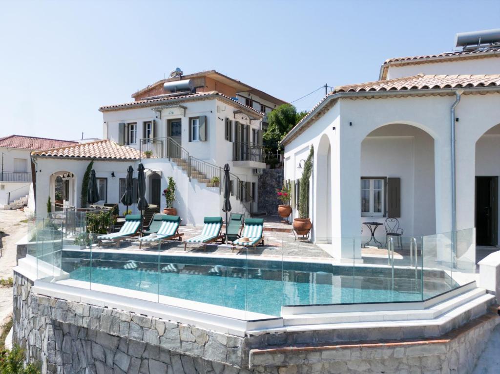 a house with a swimming pool in front of a house at Tepeleni, Parga Apts with Pool in Agiá