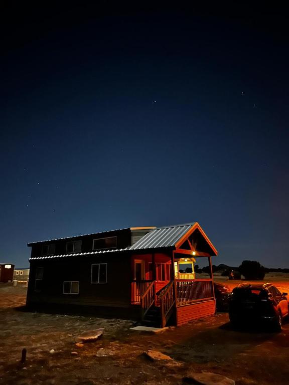 a small house with a porch in a field at 036 Tiny Home nr Grand Canyon South Rim Sleeps 8 - Full Kitchen in Valle