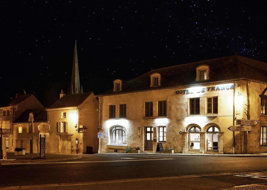 oświetlony budynek na ulicy w nocy w obiekcie Hôtel de France w mieście Saint-Savin