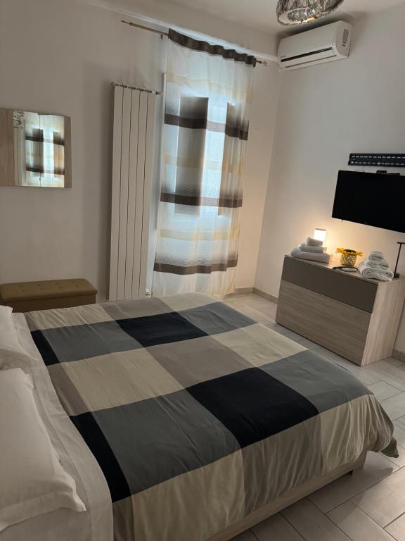 a bedroom with a bed and a tv on a wall at Eleven Home in Bari