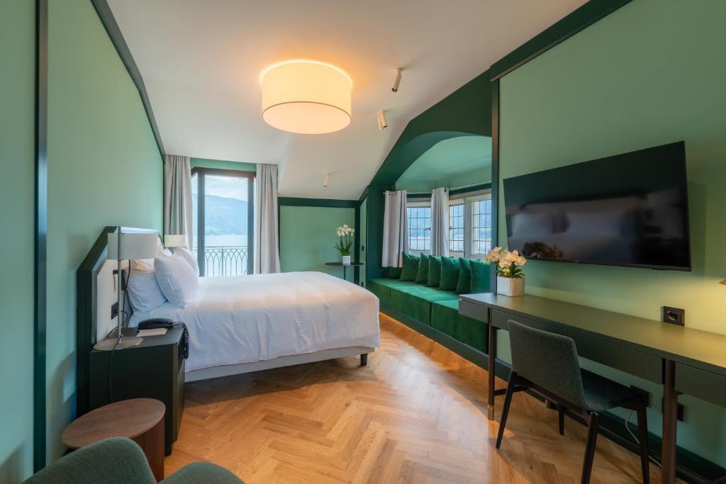 a bedroom with a bed and a desk and a tv at Casa Du Lac, by R Collection Hotels in Varenna