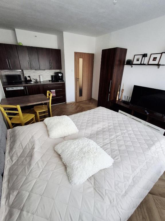 a large white bed in a room with a kitchen at Apartmán PRAHA in Martin
