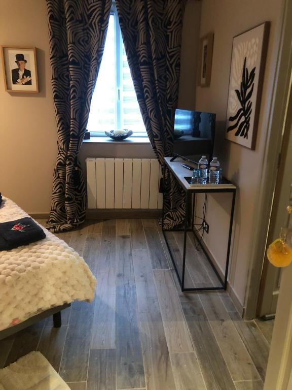 a room with a bed and a window with a table at Pensée in Huelgoat