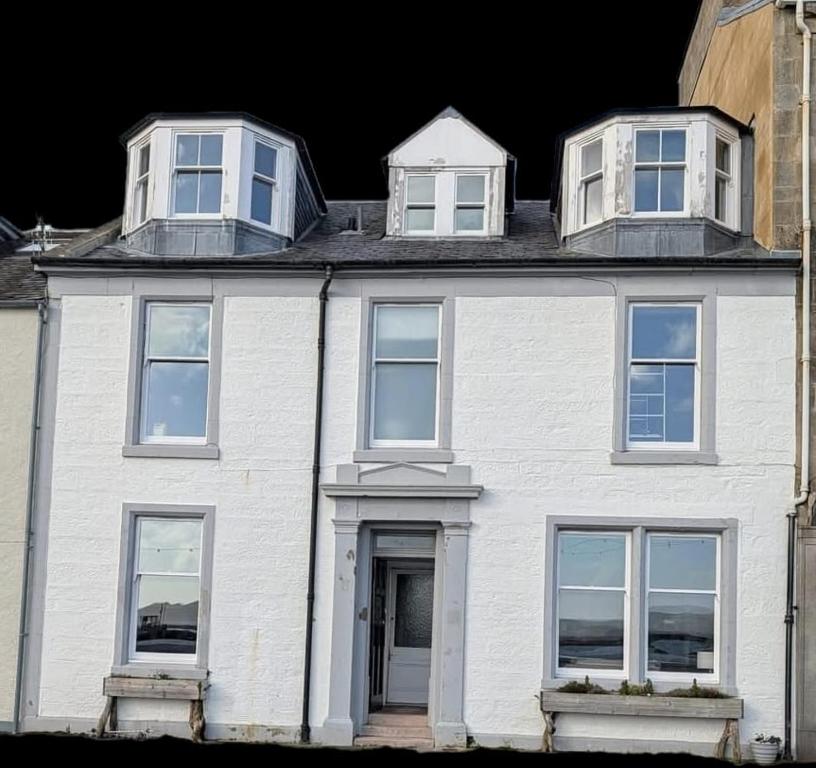 a white house with three windows on top of it at The Old Bank bed & breakfast in Millport
