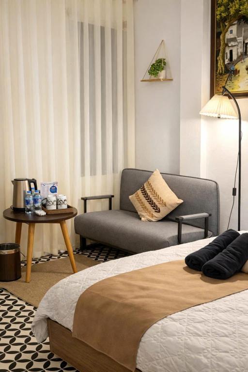 a bedroom with a bed and a couch and a table at Old Quarter Lake House in Hanoi