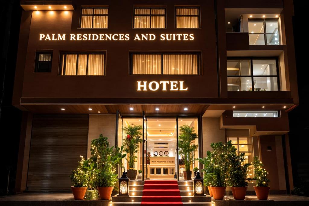 a hotel entrance with potted plants in front of it at Palm Residences and Suites in Jaipur