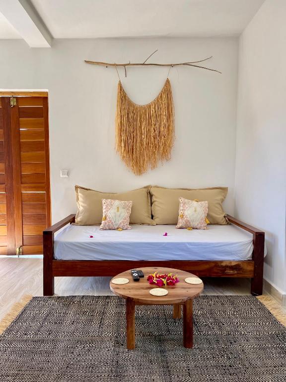 a living room with a bed with a table at Le petit Relais 1 in Andilana