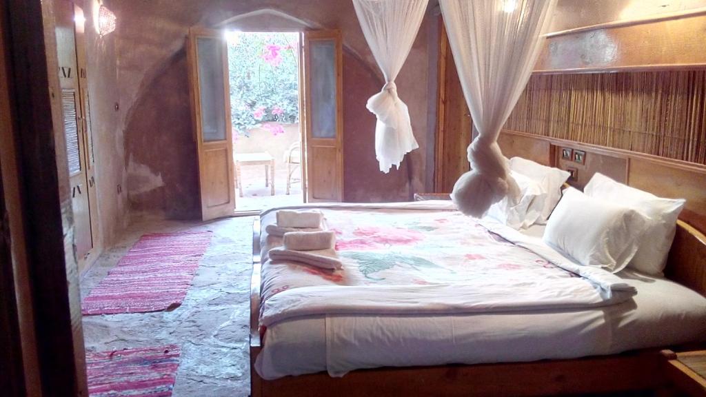 una camera da letto con un grande letto a baldacchino di Eskaleh Eco-Lodge ad Abu Simbel