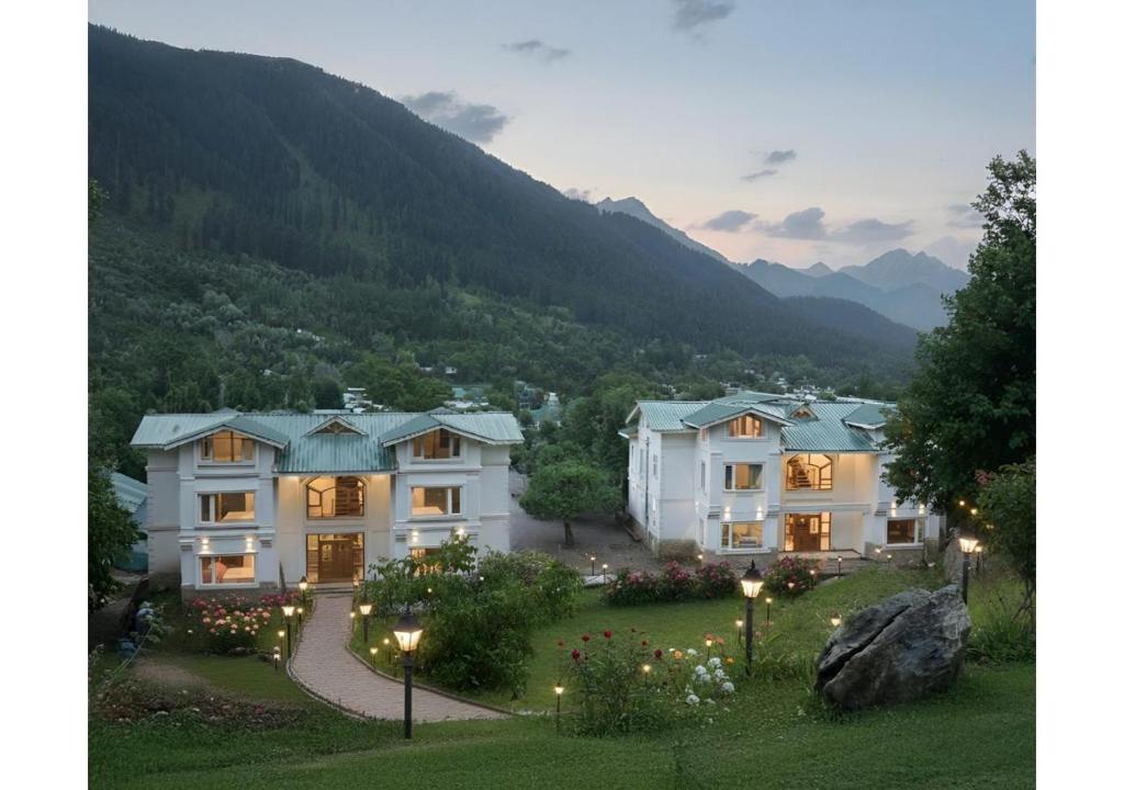 an aerial view of a house with mountains in the background at The Riviera Hotel Pahalgam in Pahalgām
