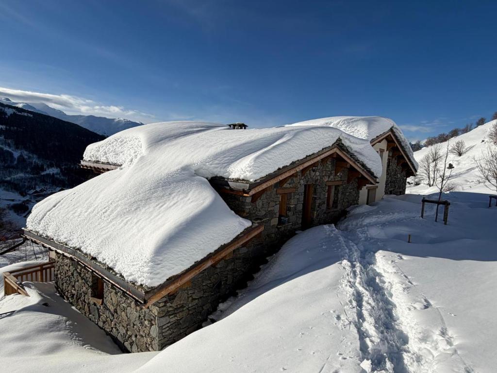 a log cabin covered in snow on a mountain at Les Chryolles -Les Petits loups in Valmeinier