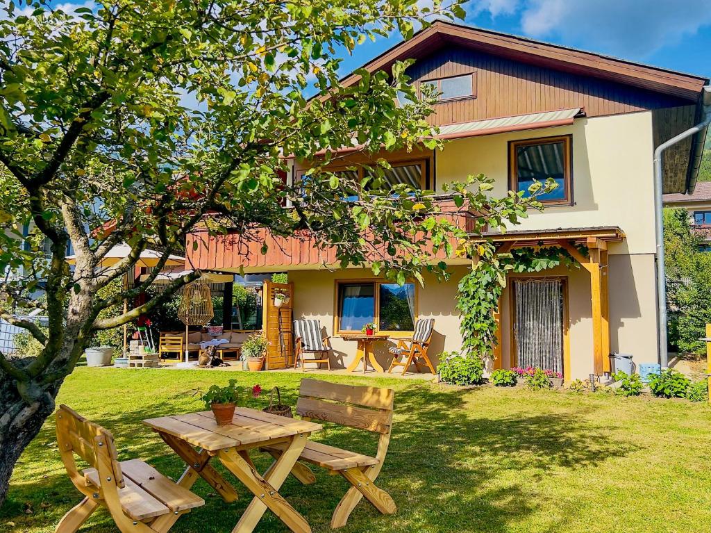 a house with a table and chairs in the yard at Einfach bei uns in Fresach