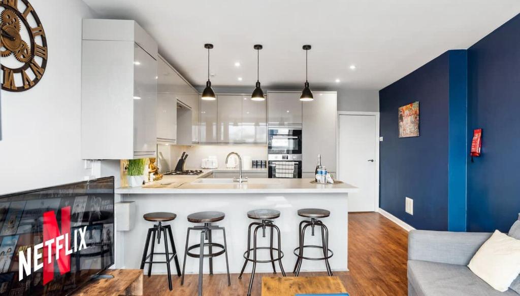a kitchen with blue and white walls and bar stools at 'Bright Gem by the Sea' Premium Central 2 bedroom flat in Brighton & Hove