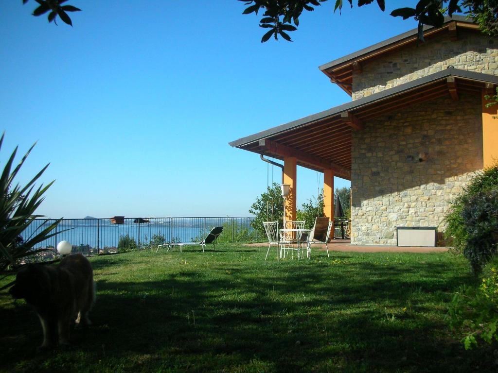 een tuin met stoelen en een huis met de oceaan op de achtergrond bij Villa Susina in Toscolano Maderno