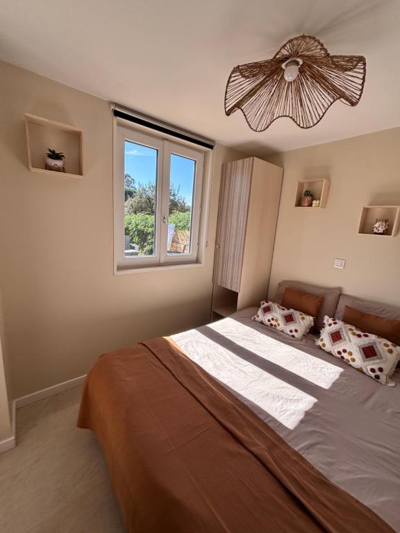 a bedroom with a large bed with a chandelier at Chalet Cosy 6 personnes in Gassin
