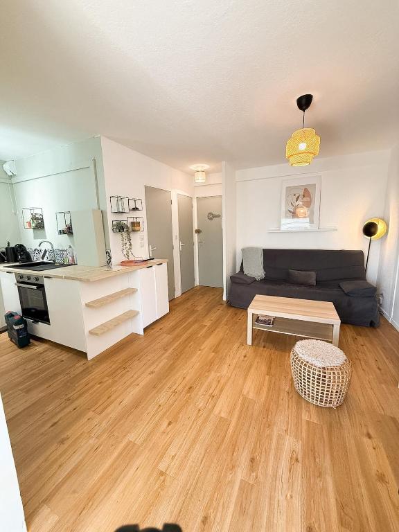 a living room with a couch and a table at L'Ecrin du Verdon - T2 avec Balcon in Gréoux-les-Bains