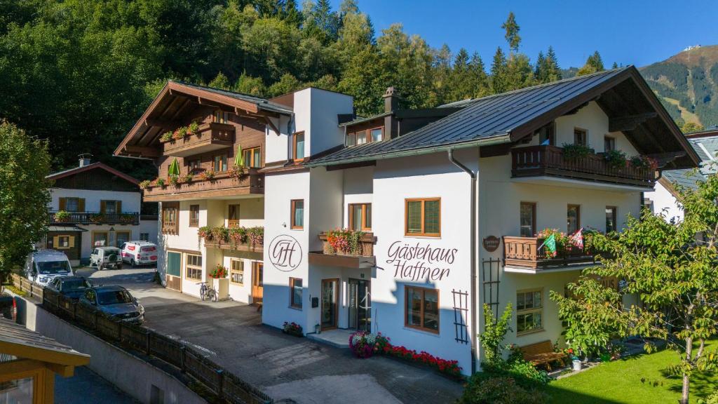 a hotel in the mountains with cars parked in a parking lot at Gästehaus Haffner in Zell am See