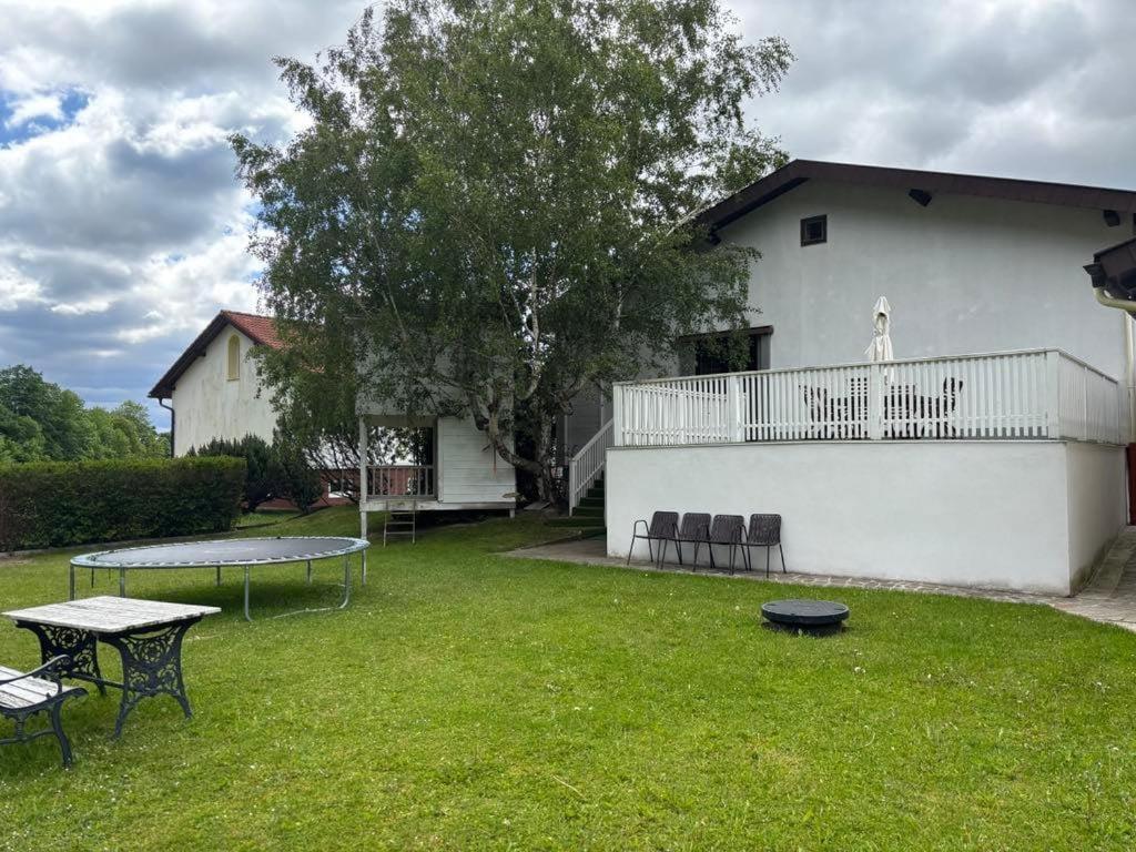 a yard with a table and chairs and a building at Garden Lodge Minou in Hirschwang