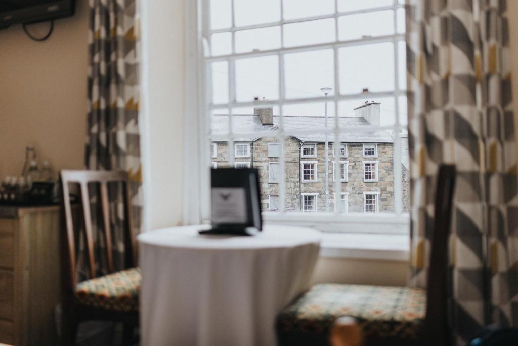 a table with a laptop on it in front of a window at Y Pengwern in Ffestiniog