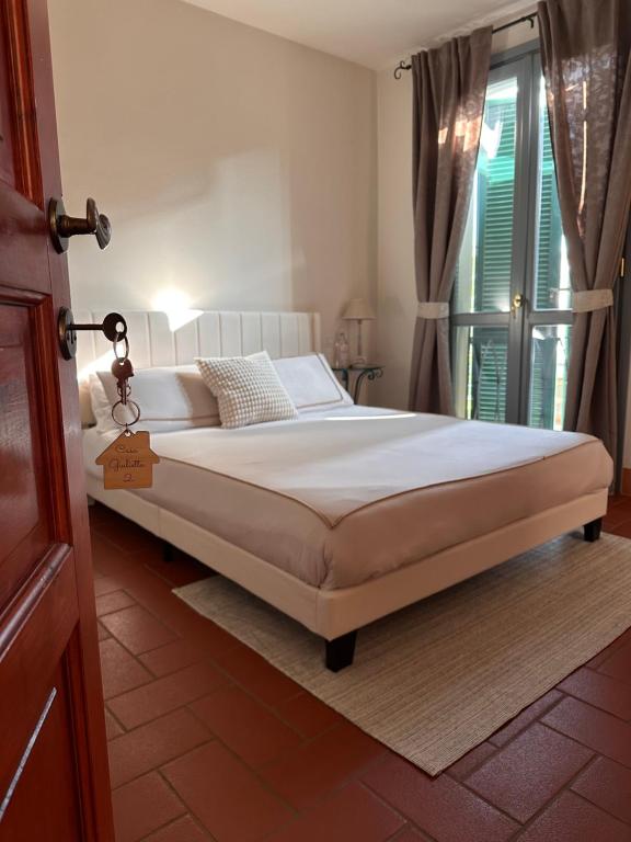 a bedroom with a white bed with a window at Casa Giulietta B&B in Santarcangelo di Romagna