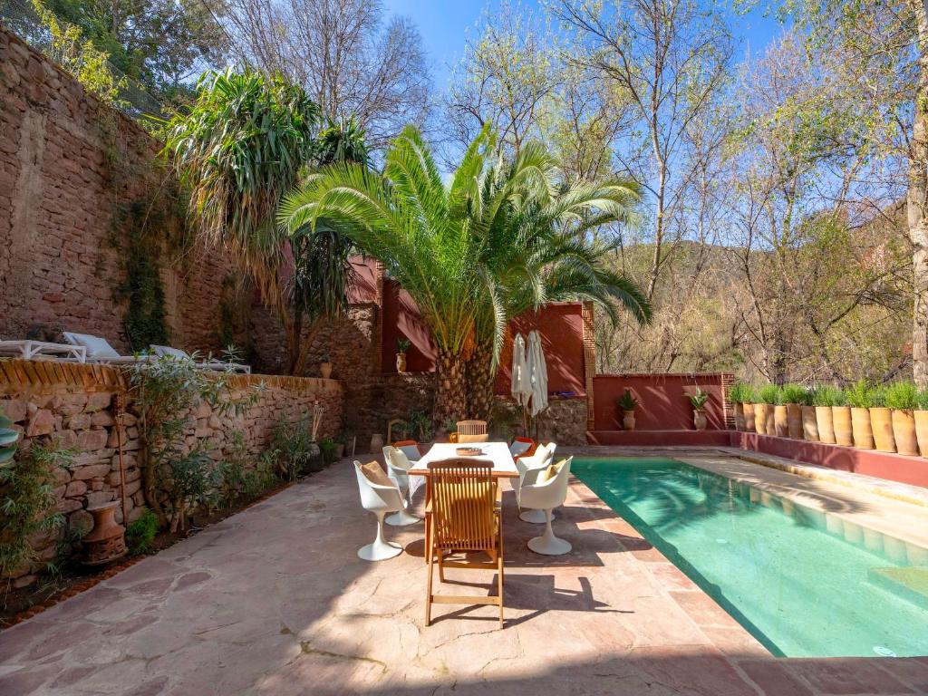 a patio with a table and chairs next to a swimming pool at Palais Laila in Tighfert
